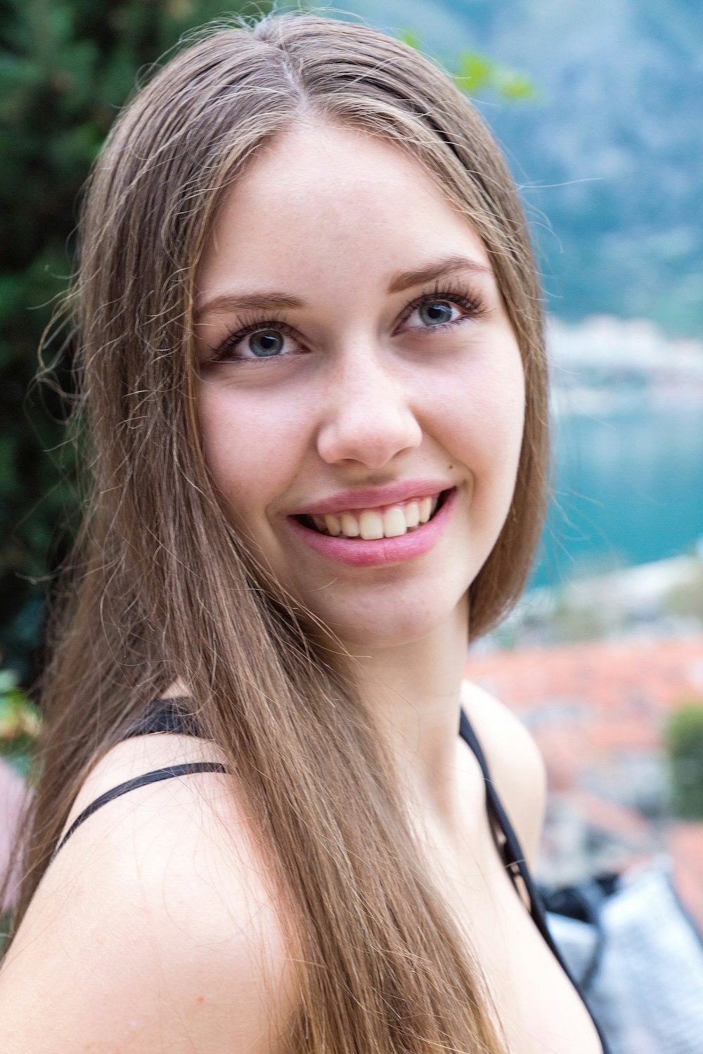 woman in black tank top smiling