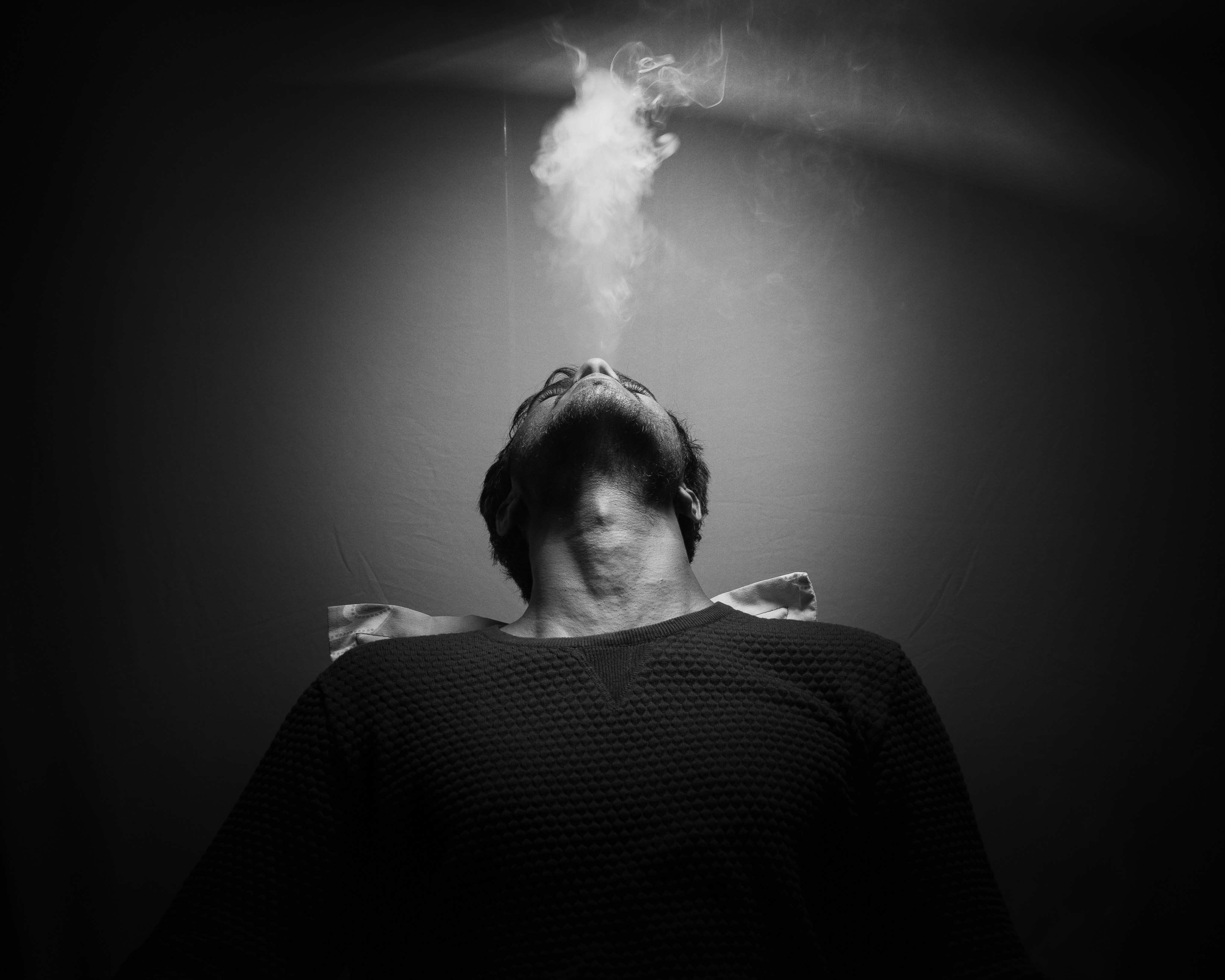 man in black and white pinstripe dress shirt smoking