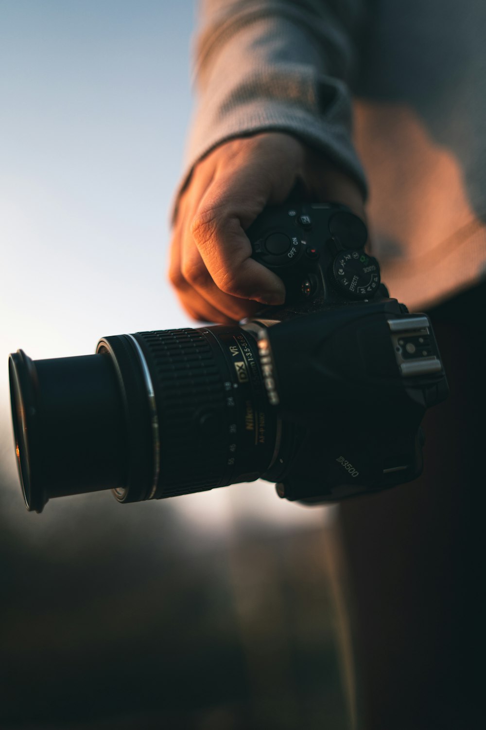 pessoa segurando câmera dslr preta