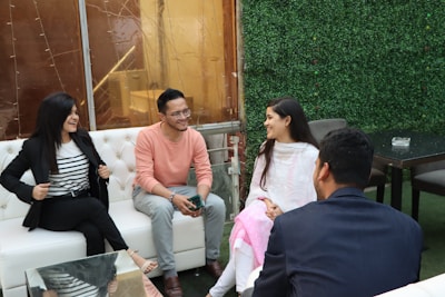 A group of diverse people sharing a supportive conversation in a bright room.