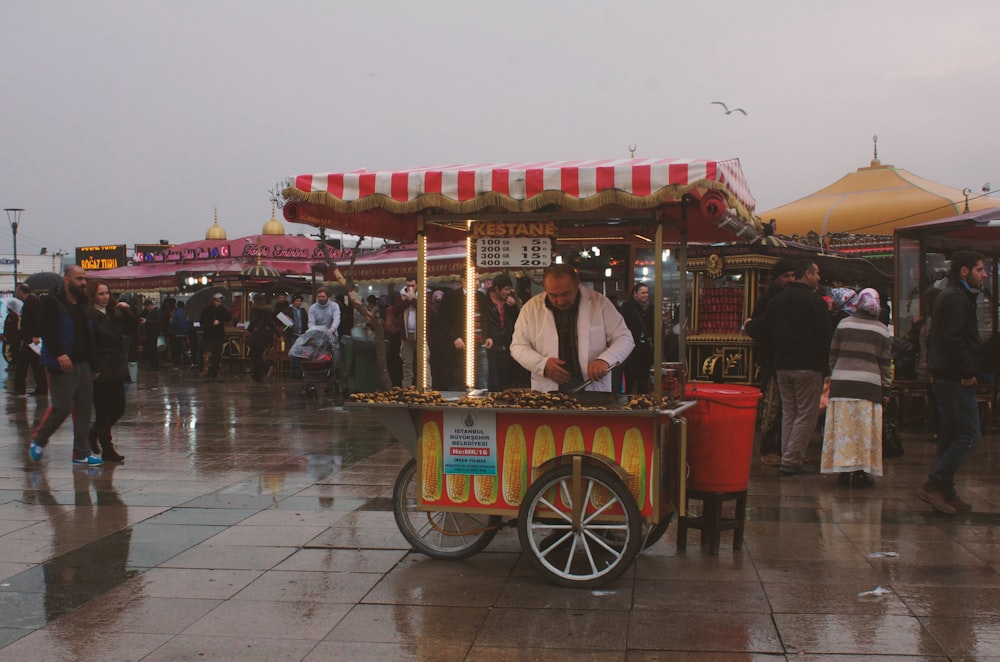 people riding on red and yellow food cart during daytime