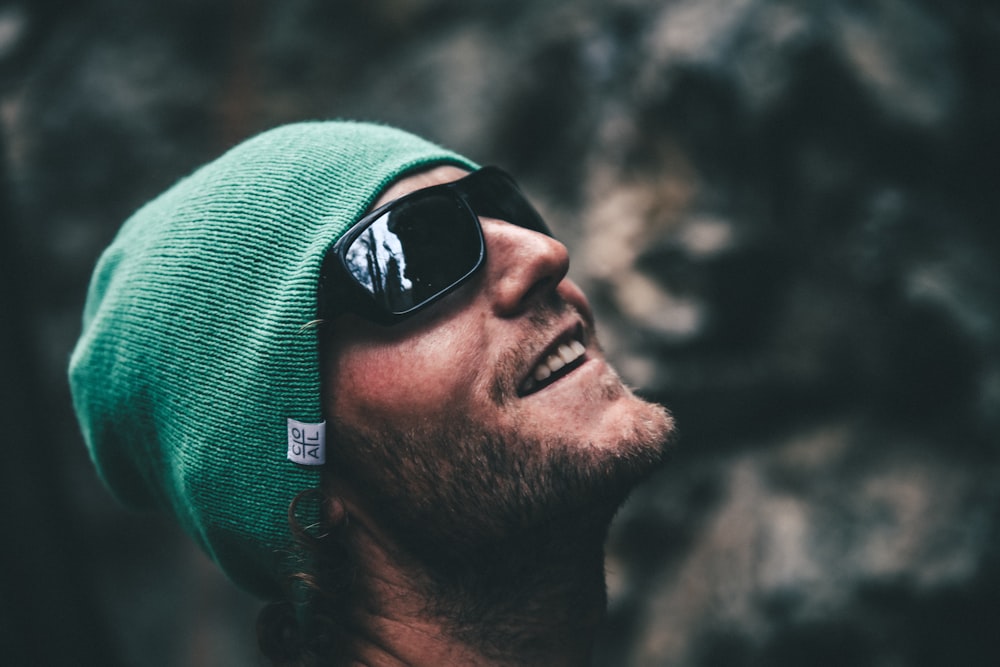 man in green knit cap and black sunglasses