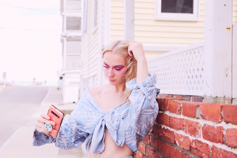 woman in blue denim jacket holding smartphone