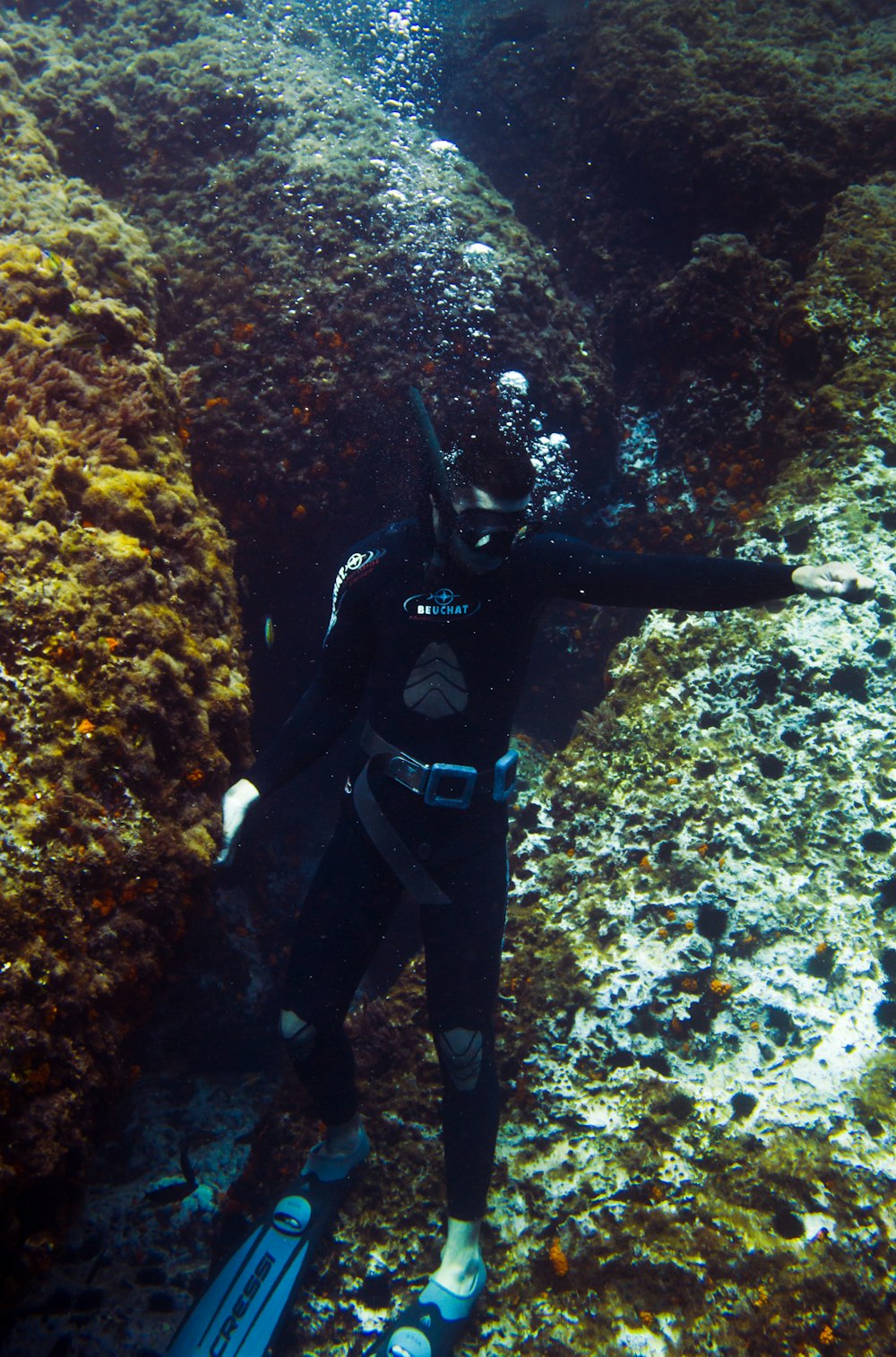 man in black and blue diving suit wearing black helmet and black goggles