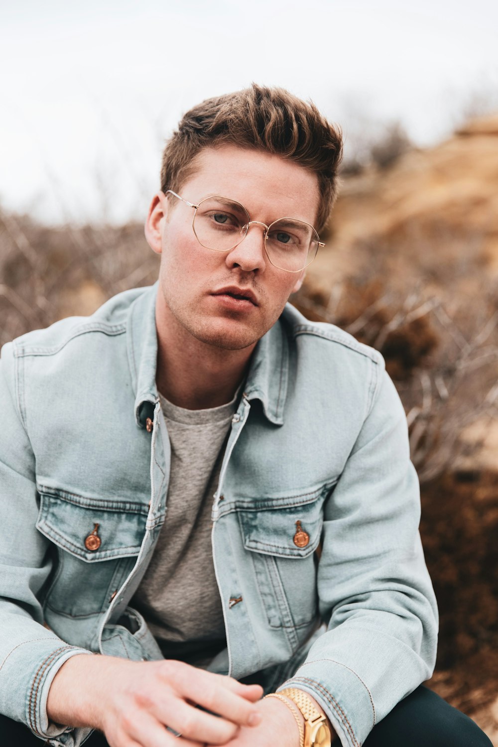 man in gray button up jacket wearing black framed eyeglasses