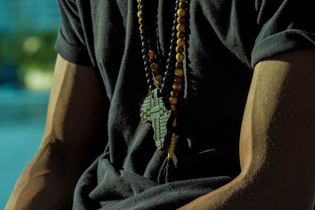 person wearing black and yellow beaded necklace