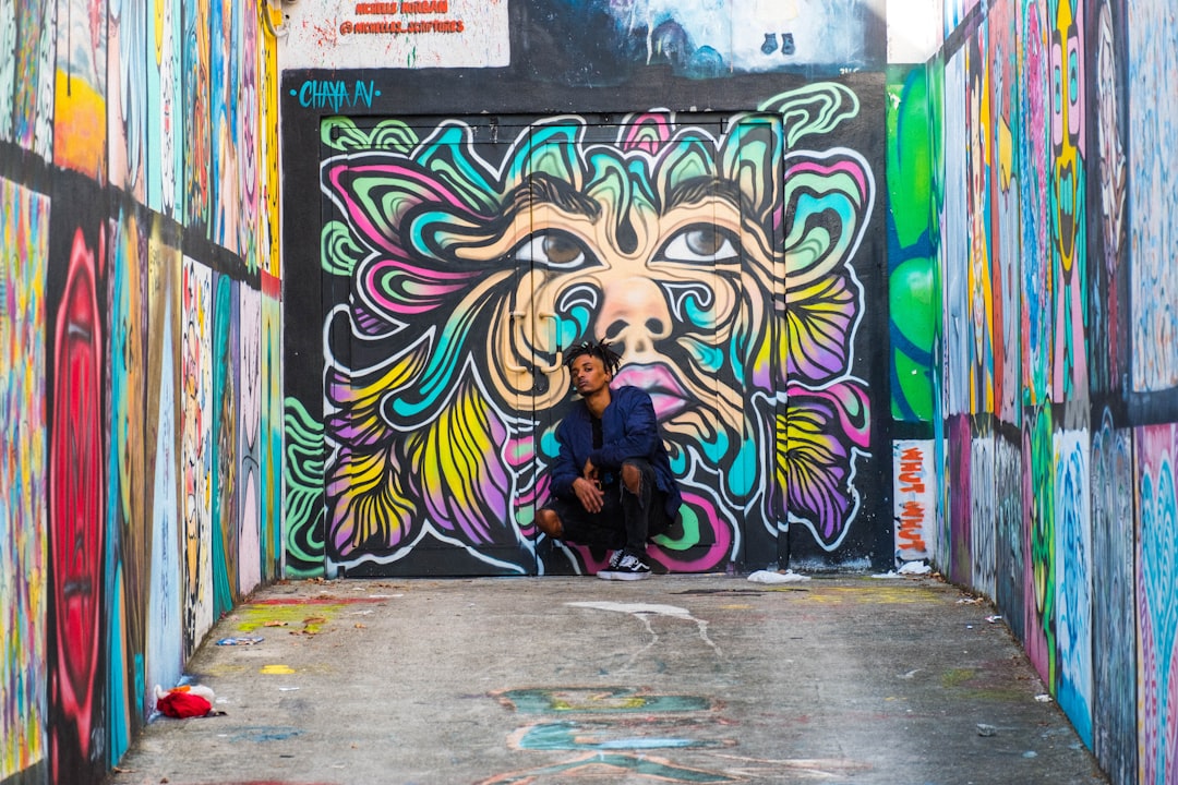 woman in black jacket standing in front of graffiti wall