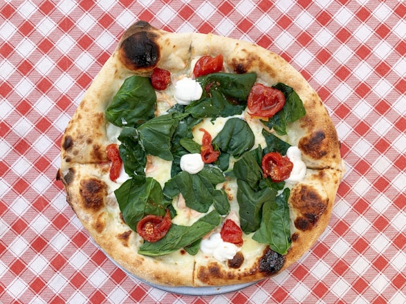 pizza with green leaves on white ceramic plate