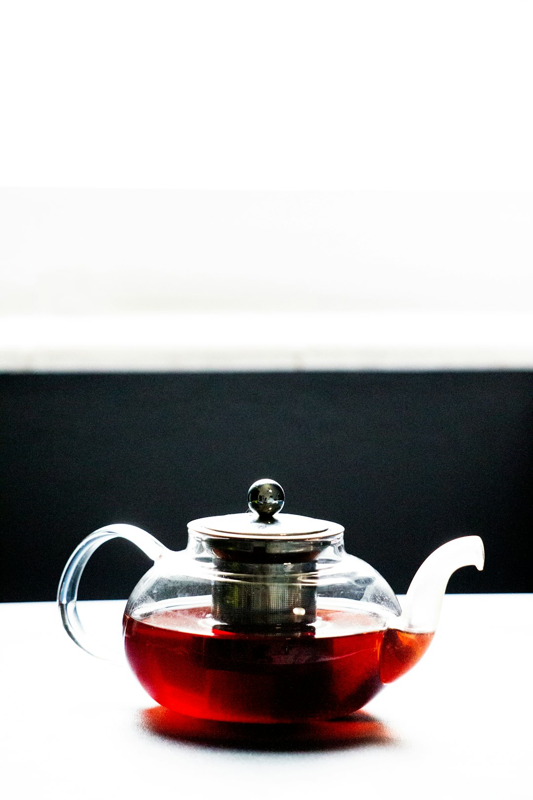 red and silver teapot on black table