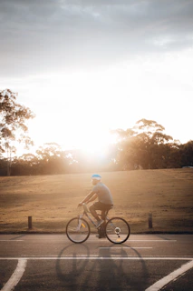 A rider wearing a Lumina helmet cruising through city streets at sunset.