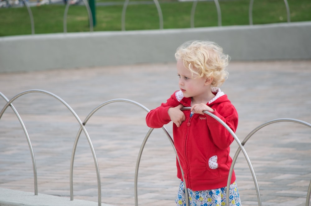 girl in red long sleeve shirt holding red hose