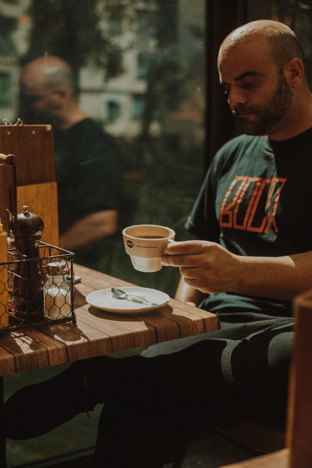 a man sitting at a table with a cup of coffee