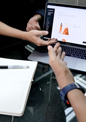 person using macbook pro on white table