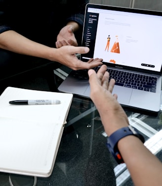 person using macbook pro on white table