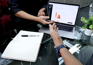 person using macbook pro on white table