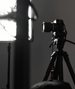 black camera on tripod in grayscale photography