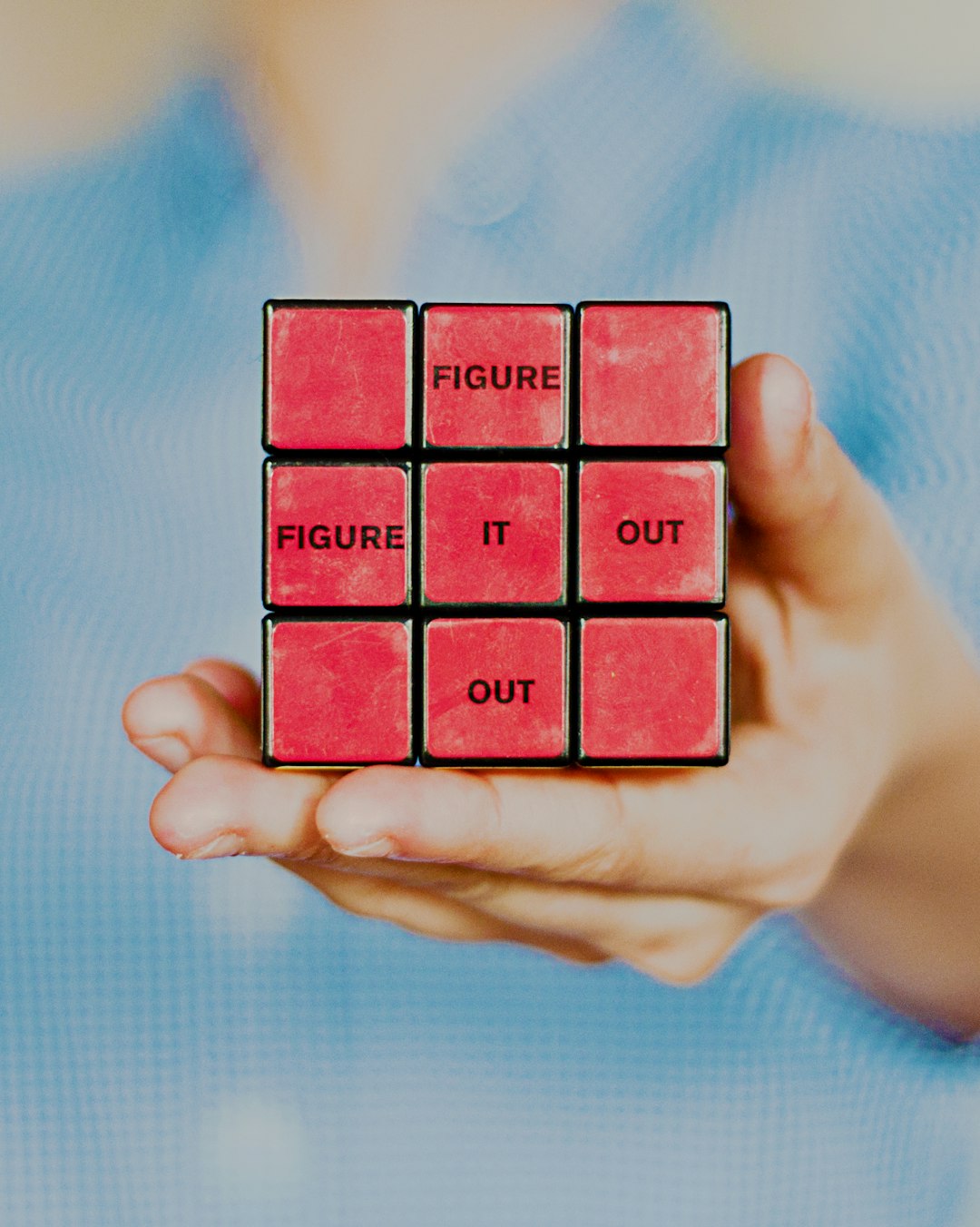 Person holding a solved rubik's cube with the words "figure it out".
