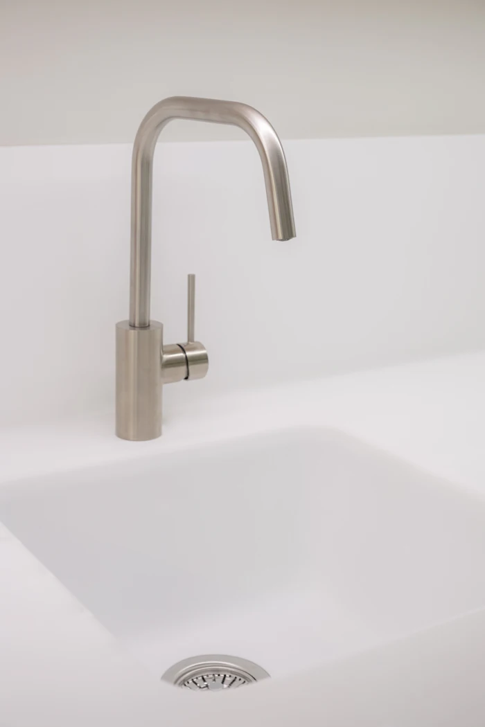 Rubinetto in acciaio inox su lavello in ceramica bianca — TopIdraulica