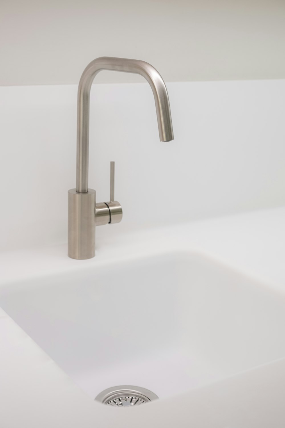 stainless steel faucet on white ceramic sink