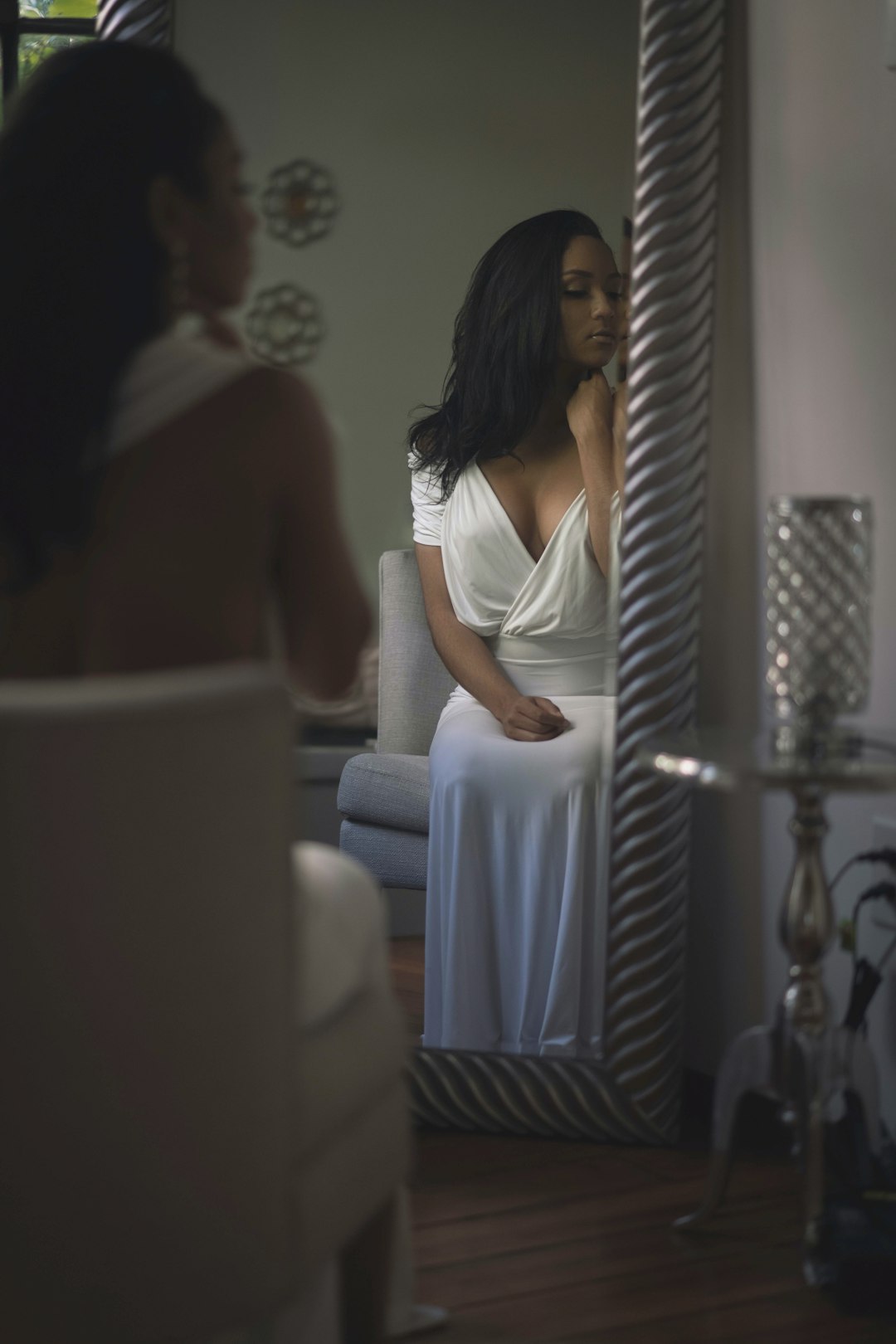 woman in white sleeveless dress standing beside mirror