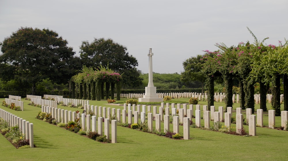 white concrete cross on green grass field during daytime