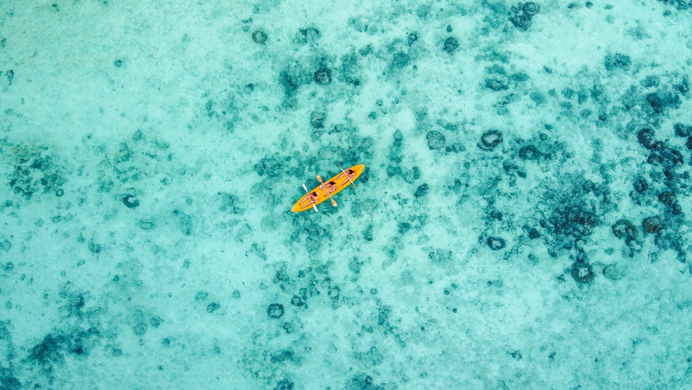 Vista aérea del barco amarillo y blanco en el cuerpo de agua durante el día