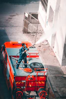 Operators and supervisors coordinating logistics with machinery and water tanker trucks in the background.
