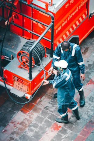 Technician in blue uniform using water extraction equipment in a flooded Brooklyn home.