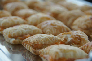 Tray of assorted savory pastries with golden flaky crusts.