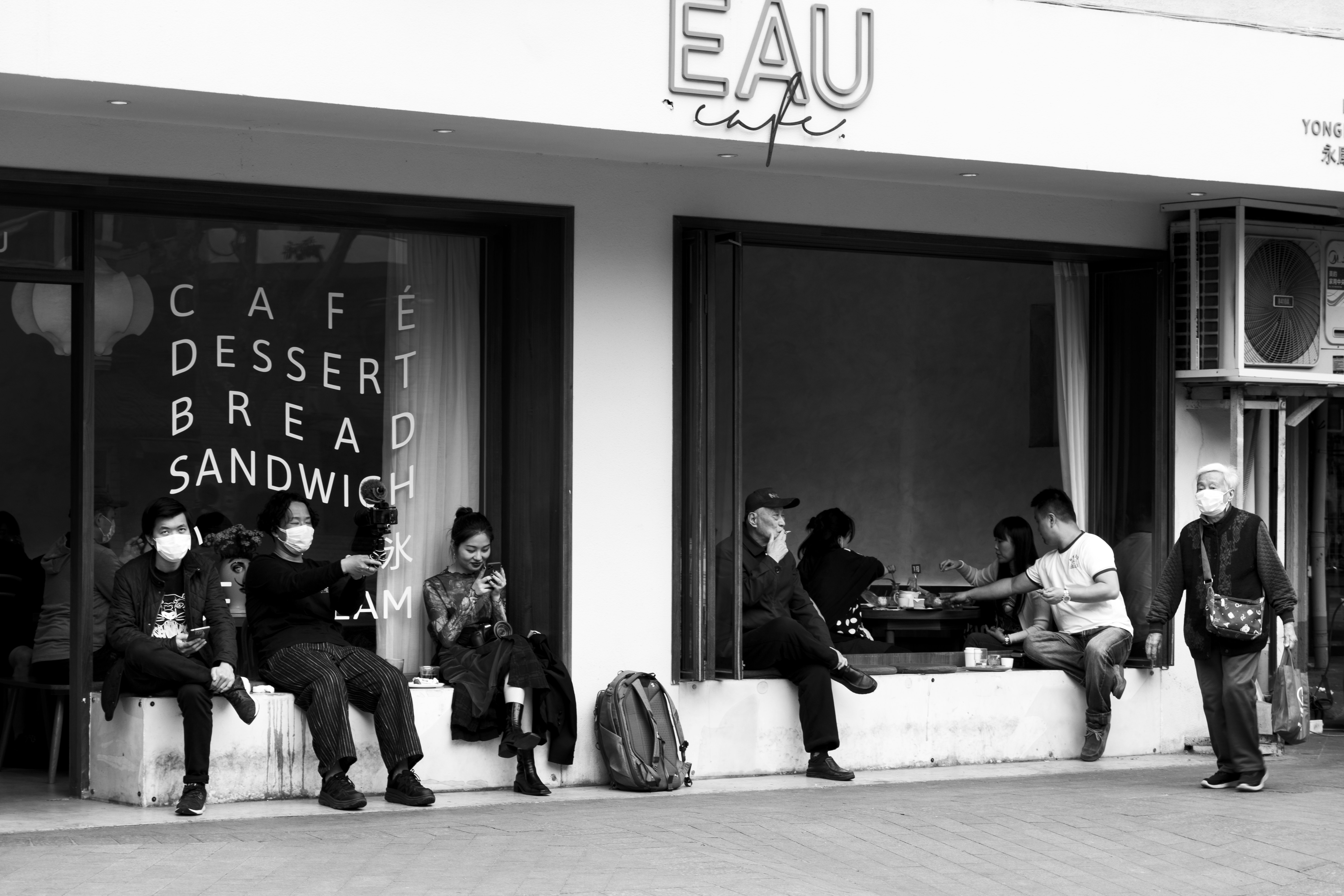 grayscale photo of people sitting on bench