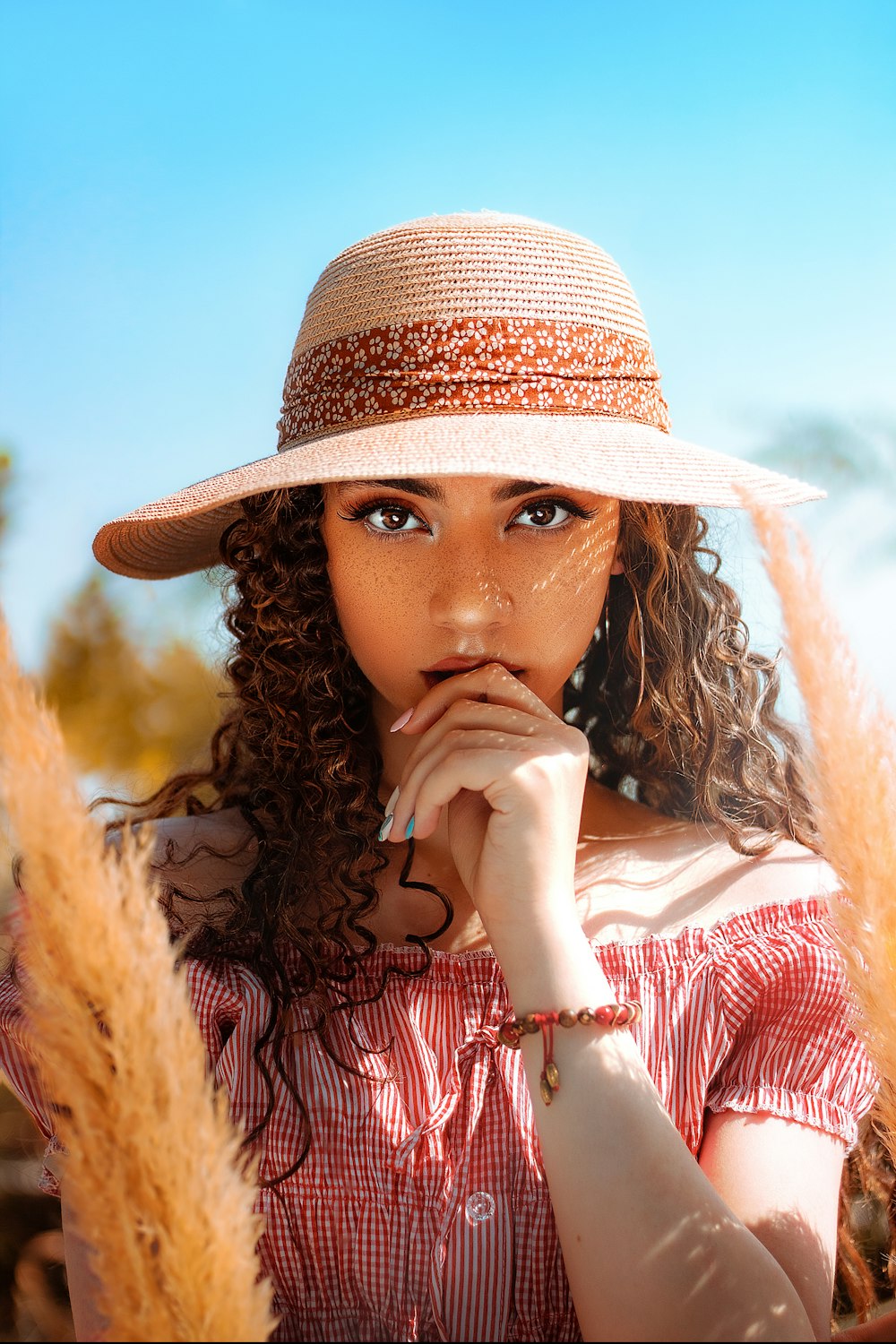 Mujer con camisa roja y blanca con sombrero marrón