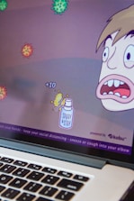 A cartoon-style computer game screen depicts a character with a surprised expression facing several floating virus illustrations. Points are indicated with '+10' near a spray bottle labeled 'Spray & Stay'. The bottom of the screen displays health advice like washing hands and maintaining social distance.