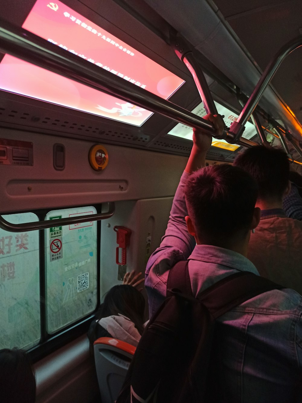 man in red jacket sitting on train