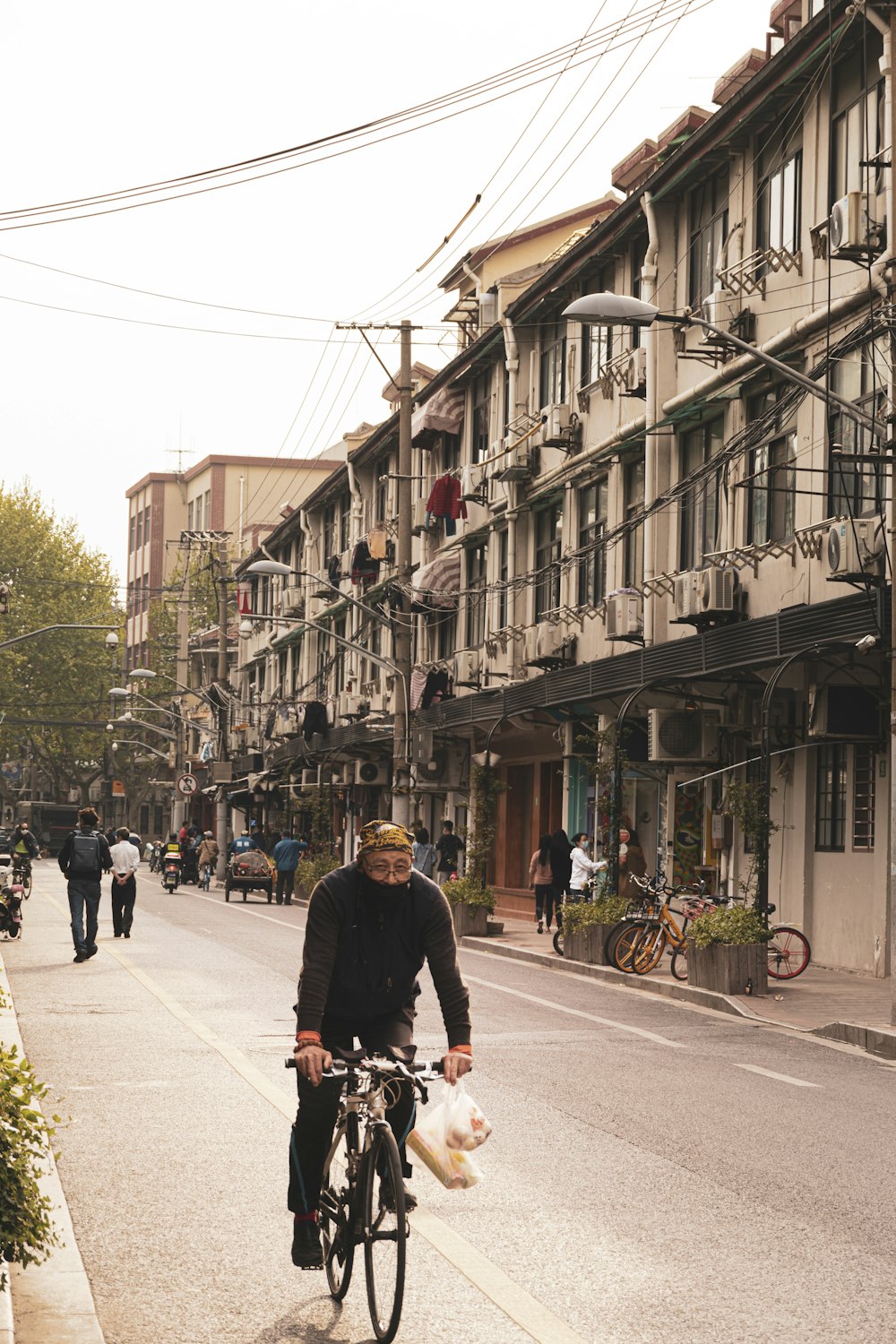 man in black jacket riding bicycle on street during daytime
