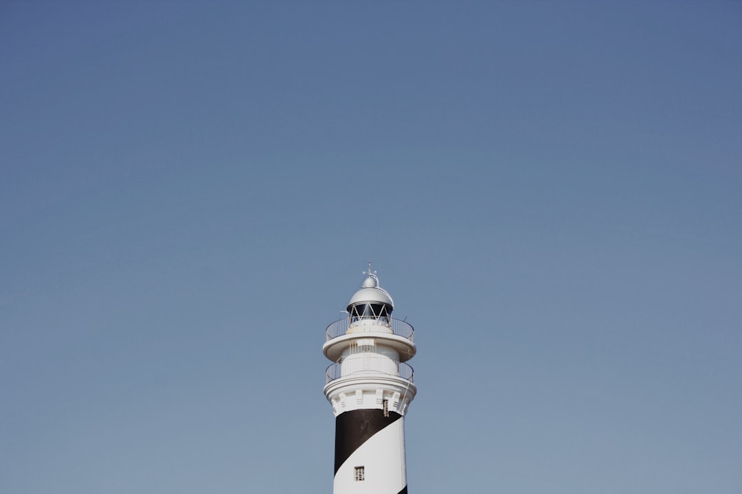 white and black lighthouse under blue sky during daytime