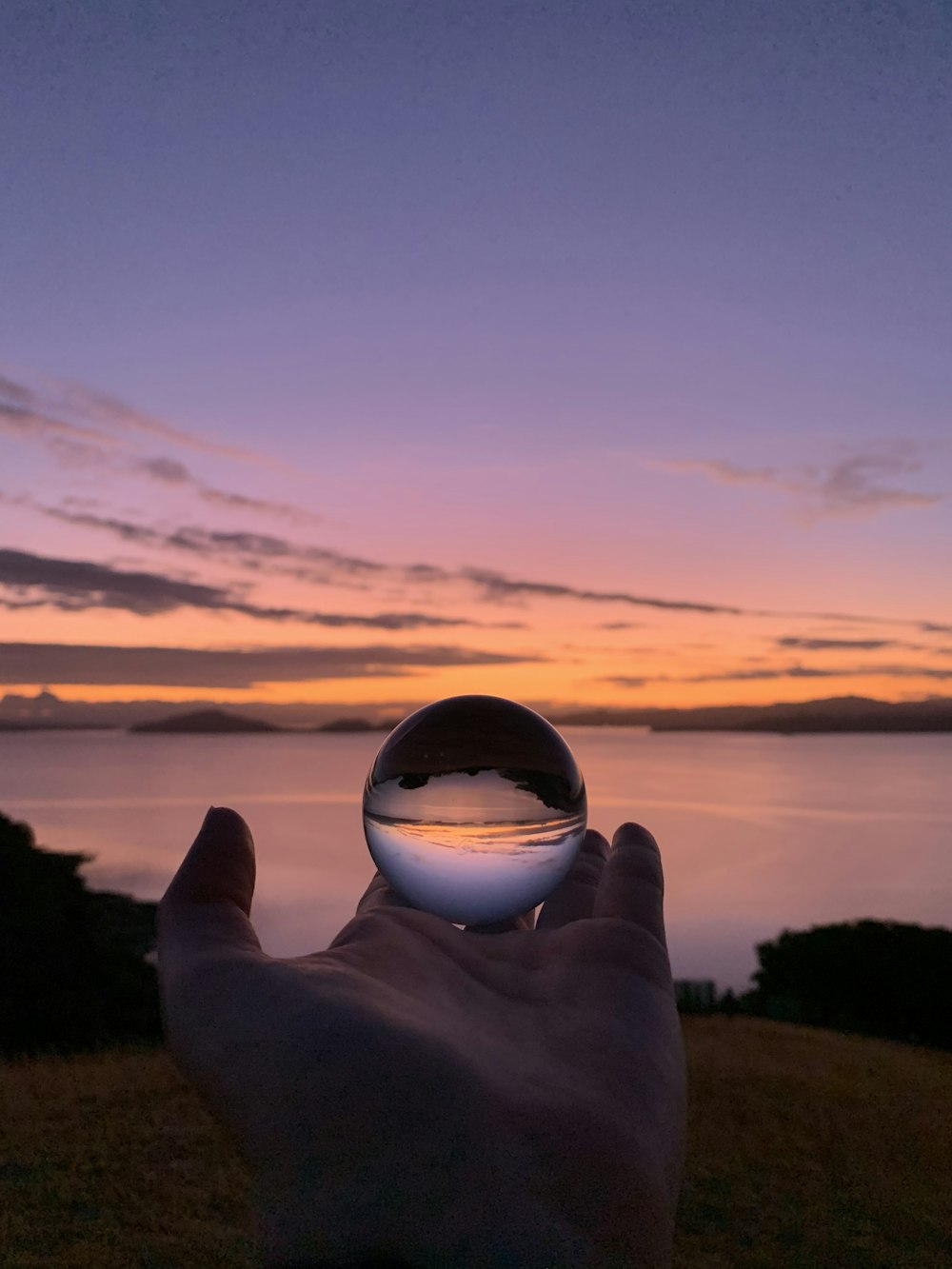 person holding clear glass ball