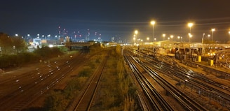 Nighttime shot of illuminated railway tracks stretching into the distance.