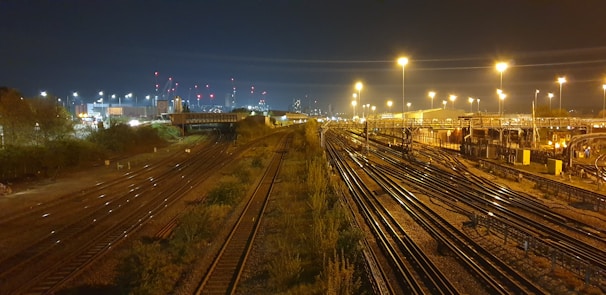 Nighttime shot of illuminated railway tracks stretching into the distance.