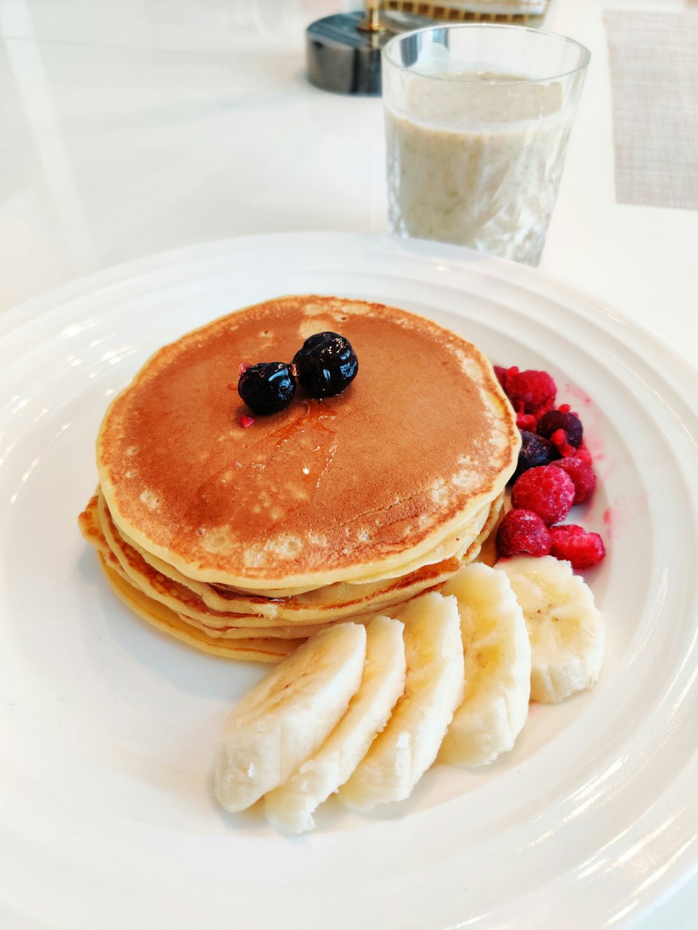 pancakes with berries on white ceramic plate