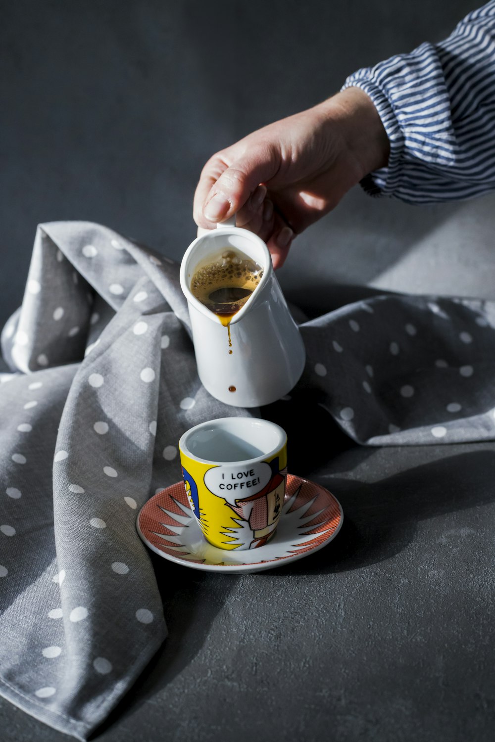 person holding white ceramic mug with saucer