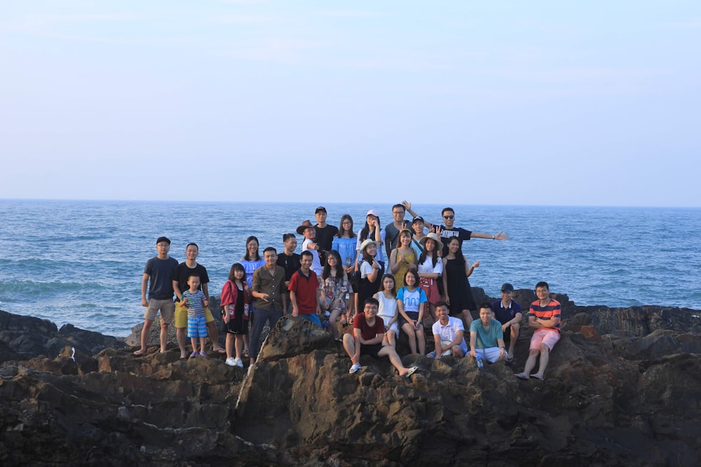 people standing on rocky shore during daytime