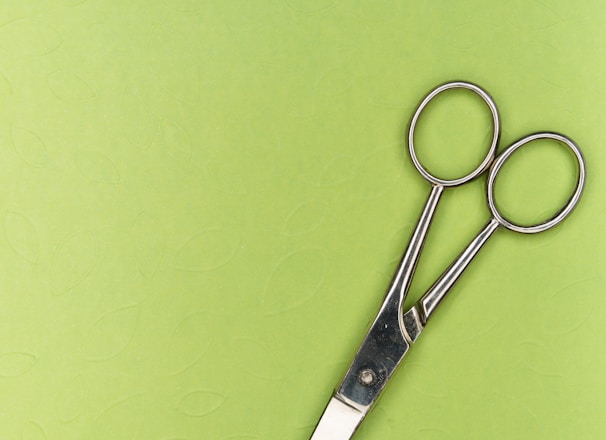 silver scissors on green surface