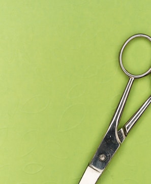 silver scissors on green surface