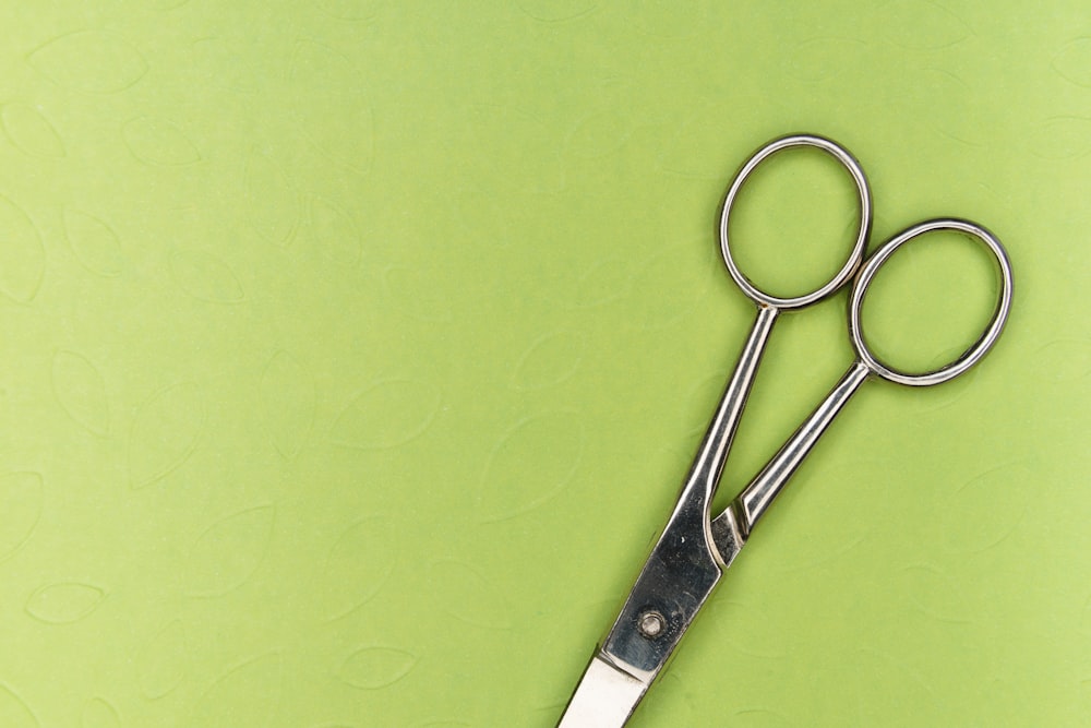 silver scissors on green surface