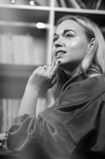 An image depicting a thoughtful author surrounded by books and notes.