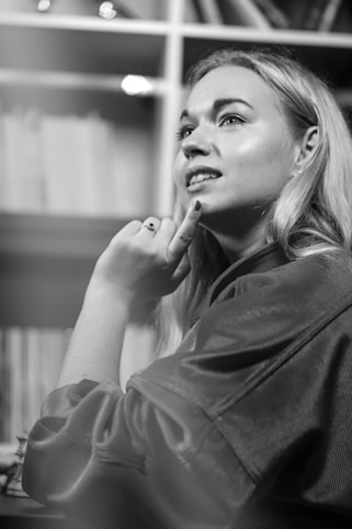 An image depicting a thoughtful author surrounded by books and notes.