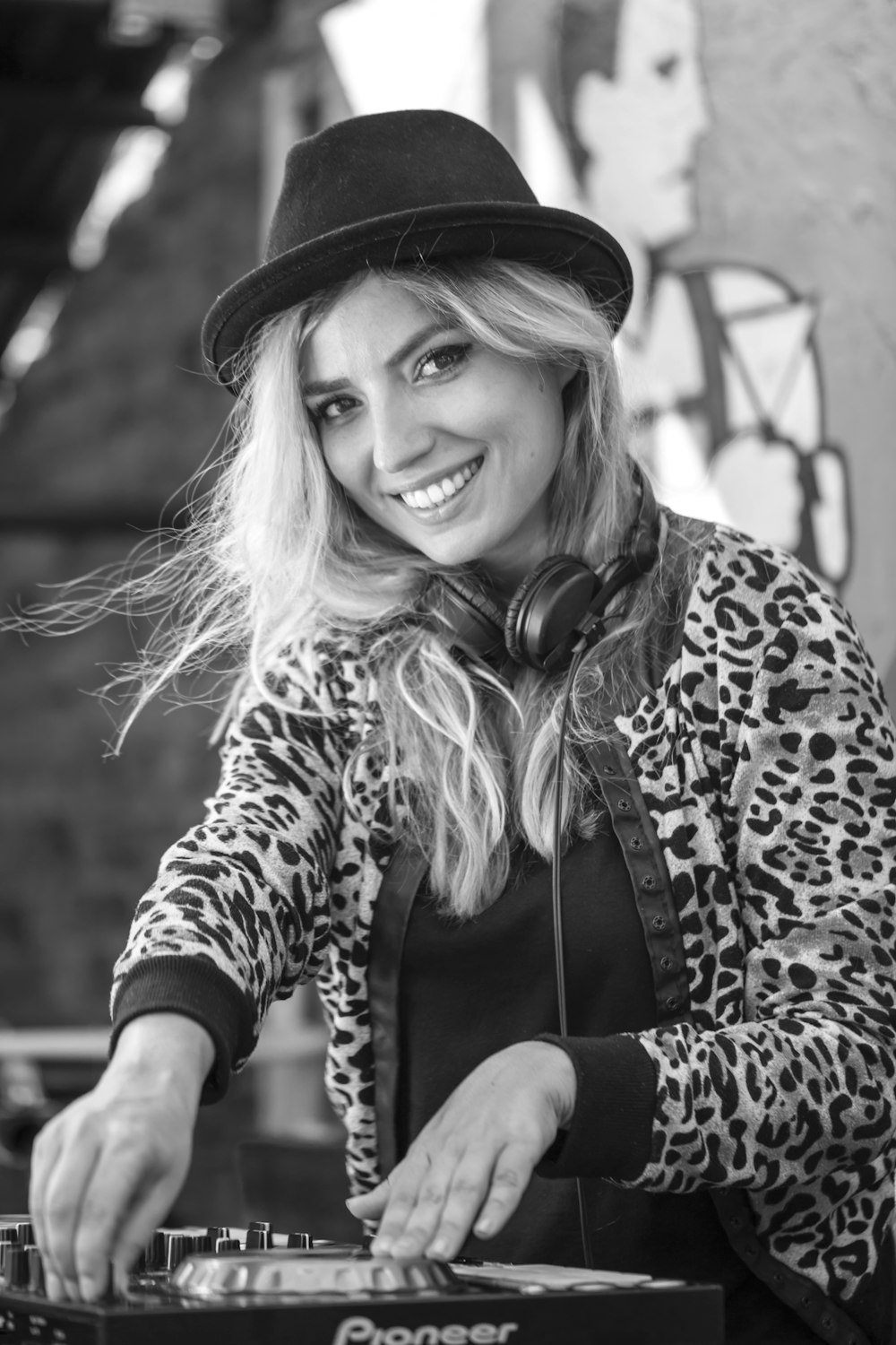 grayscale photo of woman wearing leopard print coat and hat