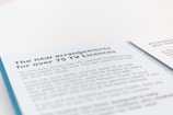 A document page with blue and white background text detailing new arrangements for TV licenses for individuals over 75. The text mentions the end of free TV licenses funded by the government and provides information regarding eligibility and application.