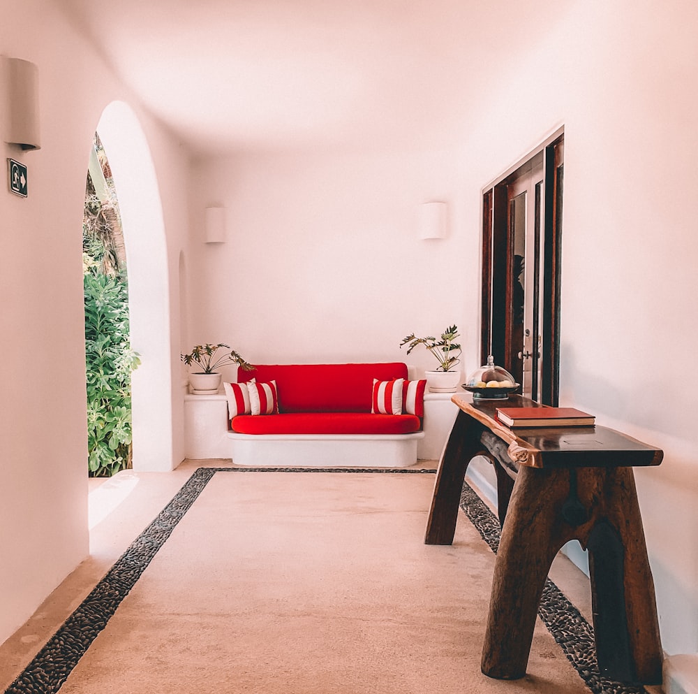 brown wooden table near red sofa