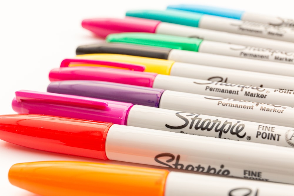 bolígrafos Sharpie de colores variados sobre superficie amarilla